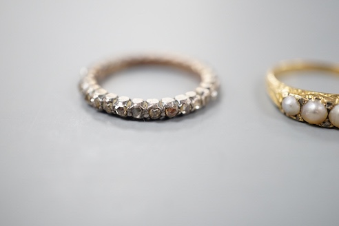 A 19th century yellow metal and rose diamond set full eternity ring, size L/M and an early 20th century yellow metal and graduated split pearl ring, size K/L, gross weight 5.8 grams.